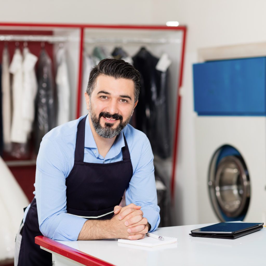 Young dry cleaner posing at camera.